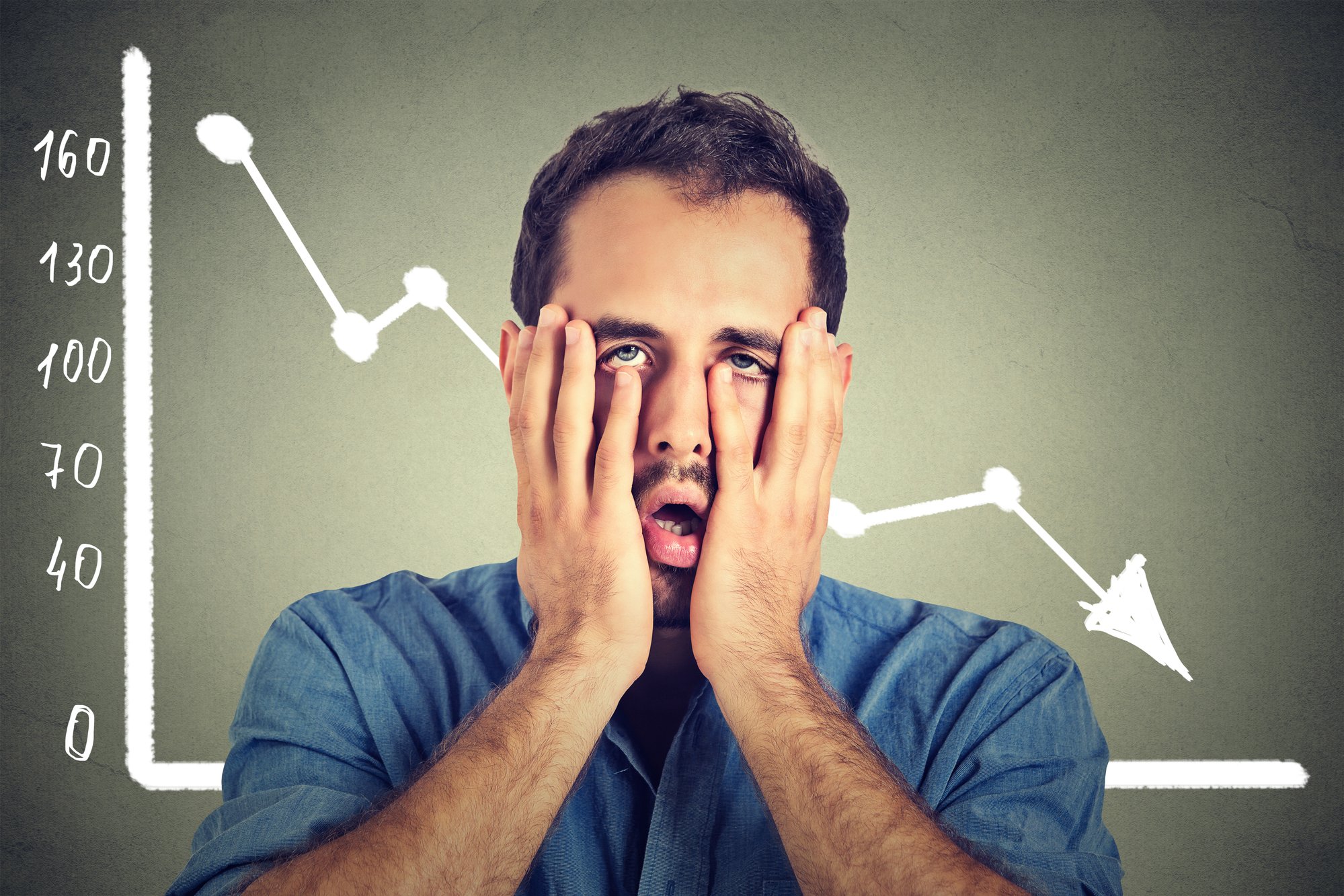 Frustrated stressed young man desperate with financial market chart graphic going down