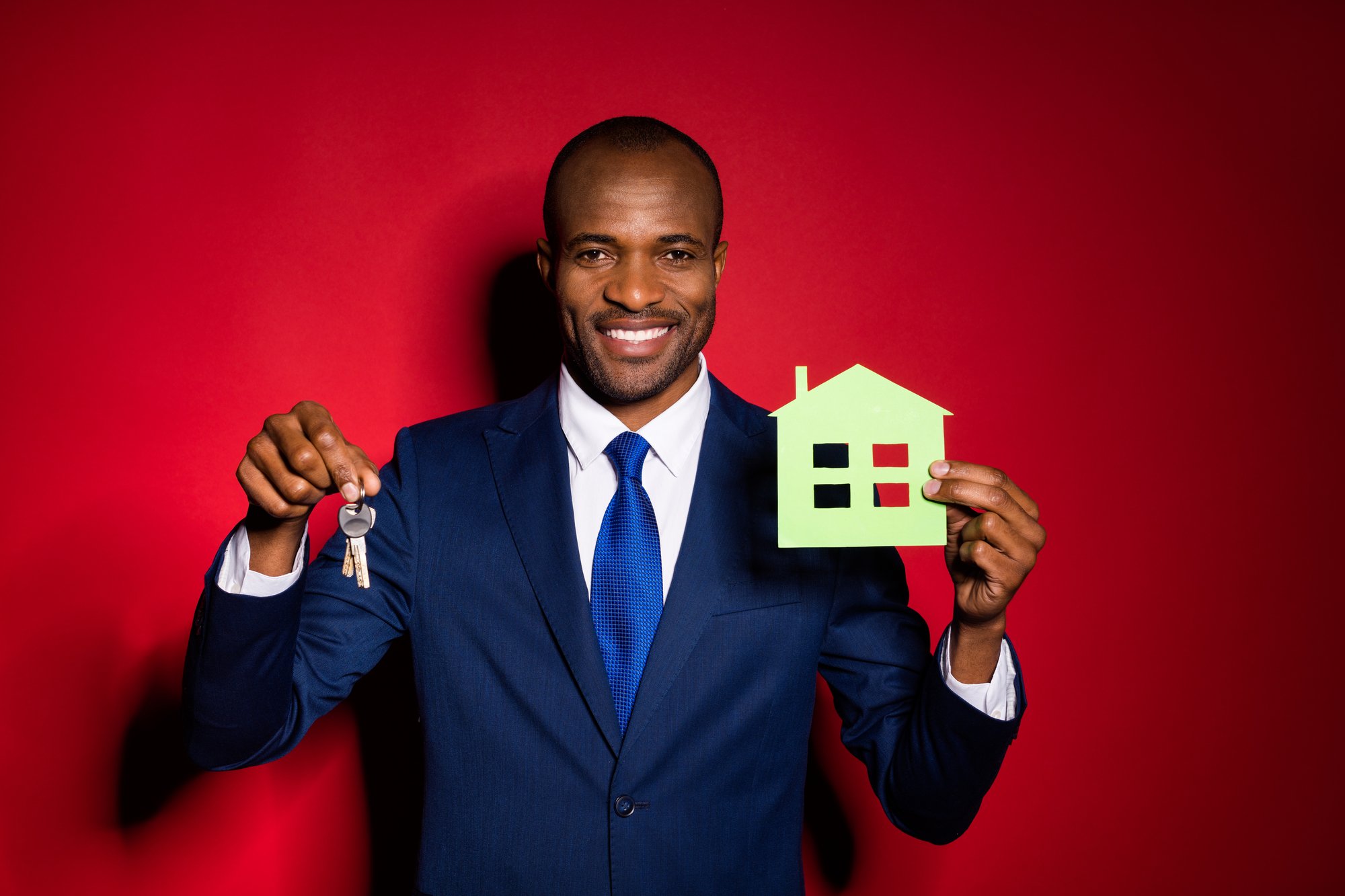 Photo of handsome dark skin business guy hold key chain green paper house real estate agent broker offer sale price wear blue formalwear suit tuxedo