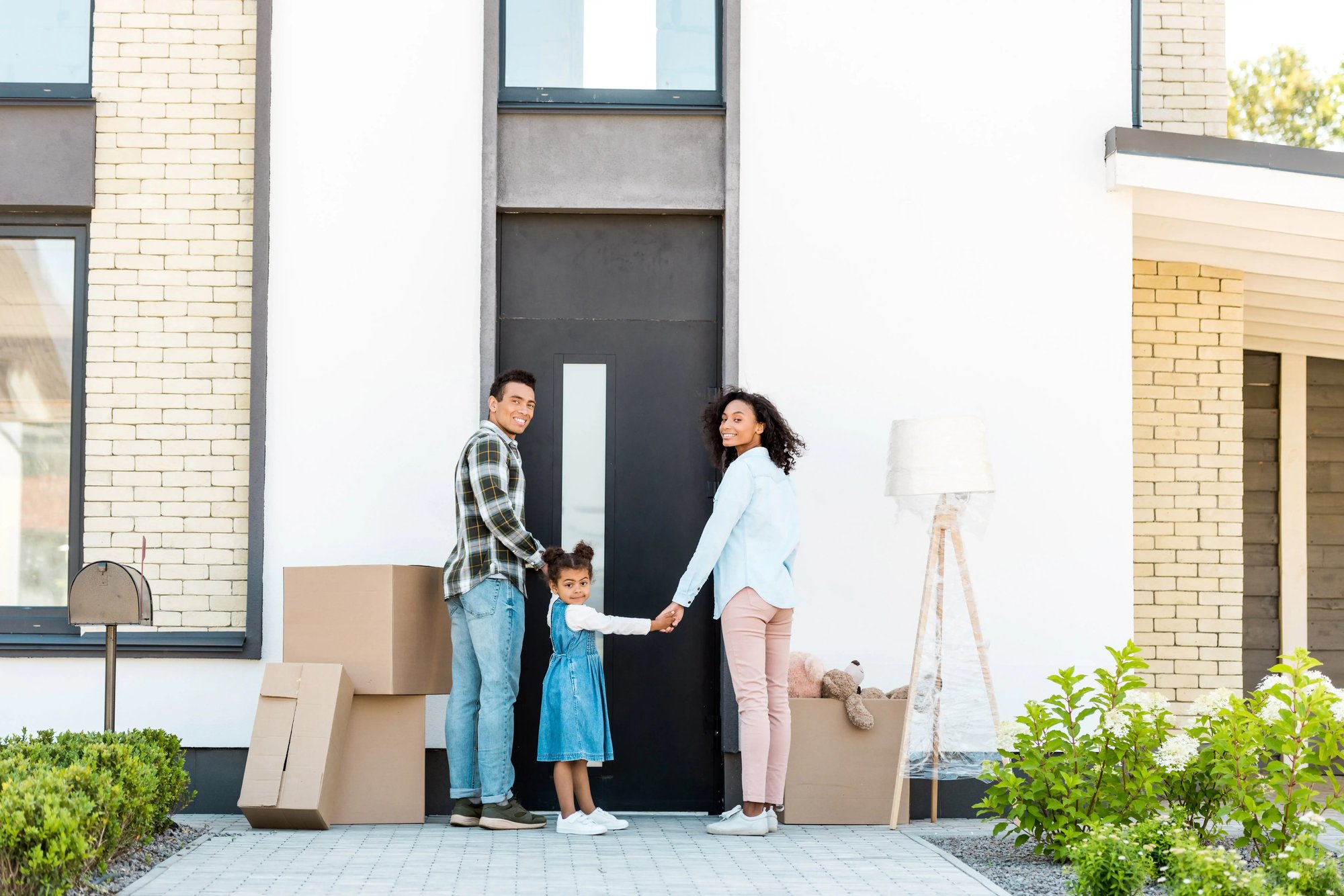 Family holding hands at door step