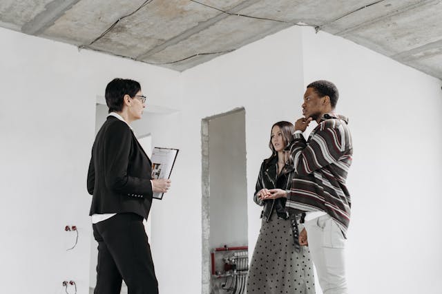 woman-with-clipboard-talking-to-two-people-in-renovated-space woman-with-clipboard-talking-to-two-people-in-renovated-space