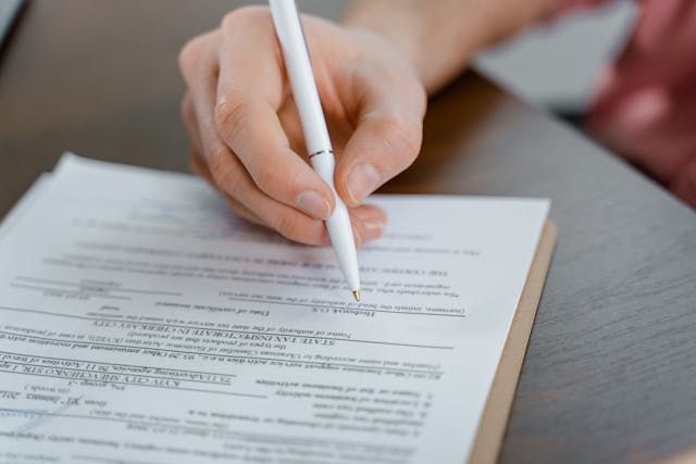 person-signing-business-papers person-signing-business-papers