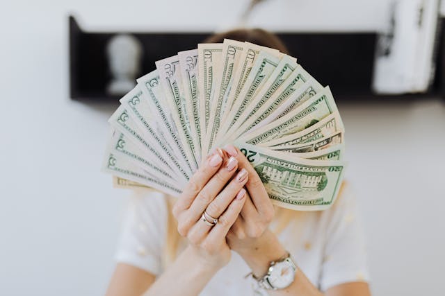 person-holding-cash-fanned-out person-holding-cash-fanned-out
